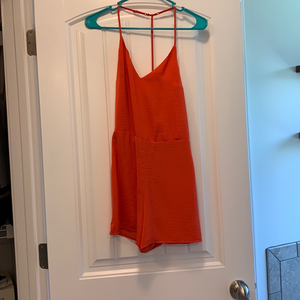 Orange romper. Zips on the side.
